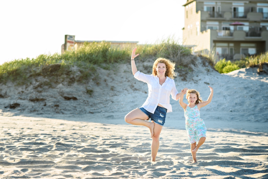 A mom and her daughter do yoga on the beach of Wildwood, NJ during their family photography session.
